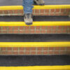 Black and yellow QuartzGrip anti-slip Stair Tread Covers installed on bicks steps